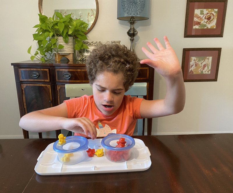 regression \ Angelman Syndrome News \ The author's daughter Juliana, 11, sits at the dining room table with an activity to help her learn colors