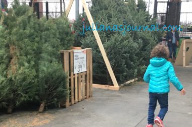 Learning to walk with Angelman | Angelman Syndrome News | Juliana, wearing a turquoise hooded jacket, runs through a Christmas tree section of a store