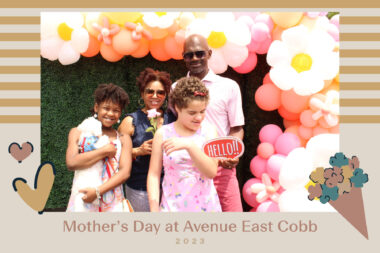 A family poses in a special Mother's Day photo booth decorated with giant balloons and flowers. 